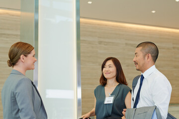 Business man and business woman meeting a concierge. Group of business people meeting their...