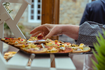 Main qui se sert sur un plateau de toasts lors d'une réception de mariage