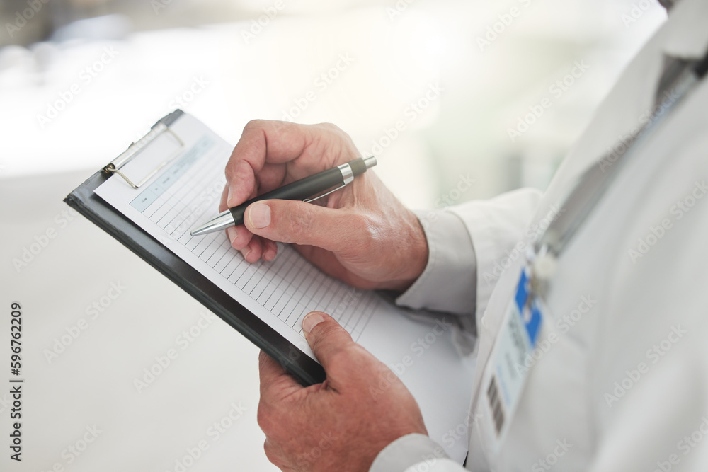 Aufkleber plans are better made on paper. shot of an unrecognizable doctor writing of a form at a hospital.