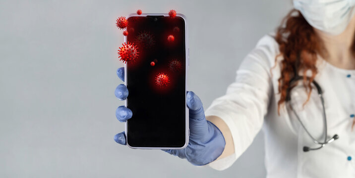 The doctor shows a mobile phone, prevents infection with a virus, germs, bacteria. Smartphone with infectious bacteria and germs on the display.