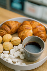 delicious fresh meringue croissants and nuts with condensed milk and coffee on a table in a cafe