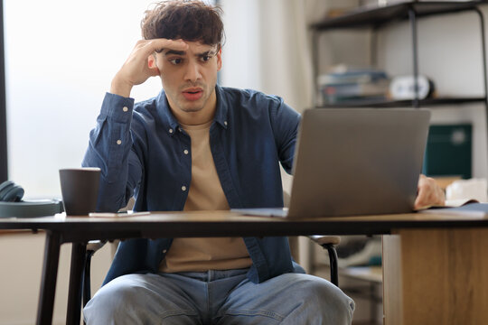 Stressed Arabic Man Using Laptop Sitting At Desk In Office