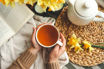 Cup of tea in hands top view, good morning concept