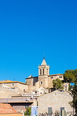 Fototapeta na wymiar Silhouette and bell tower of the church of the village of Santa Cristina de Aro in Baix Amporda in Girona, Costa Brava, Catalonia, Spain.