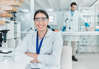 Science is the world I love getting lost in. Portrait of a young scientist sitting with her arms...