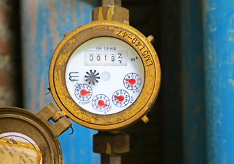 Weathered velocity water meter with pipes in the backdrop - obrazy, fototapety, plakaty