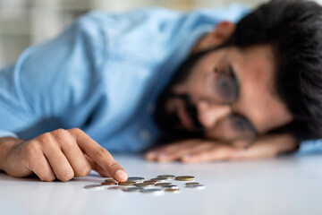 Poverty And Absence Of Money. Upset Indian Man Counting Coins On Table