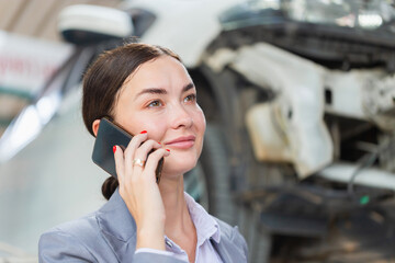 Young business woman using smartphone at repair garage, Customer making a phone call at the repair garage