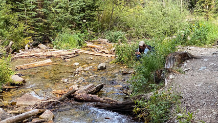 woman taking photos at a mountain creek through the forest in Breckenridge Colorado