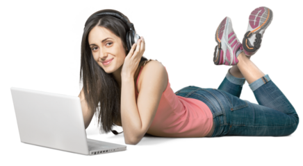 Young woman lying down in front of a laptop wearing headphones