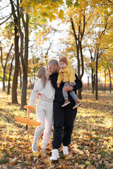 Family: mother, father and baby son playing in autumn park having fun. Family, childhood, season and people