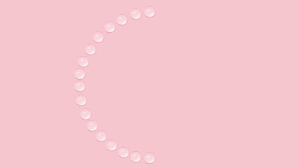 Drops of transparent gel or water are arranged in the shape of a not full circle. On a pink background.