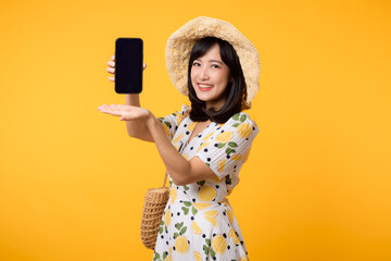 Portrait happy young asian woman with springtime dress fashion showing blank mobile application display screen for advertisement isolated on yellow background. Smartphone app technology concept.