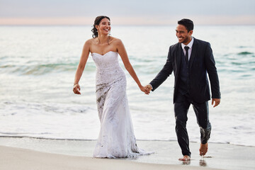 I will love you in word and deed. Shot of a young couple on the beach on their wedding day.