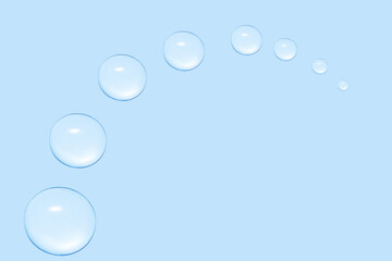 Drops of transparent gel or water in the shape of a semi-circle, with decreasing size. On a blue background.