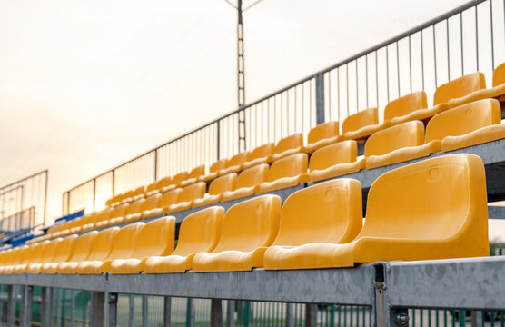 Empty vacant small stadium seats outdoors, bleachers, nobody, no people, cancelled sports event, nobody present at a sport show simple abstract concept. Chair rows up close, copy space, side view