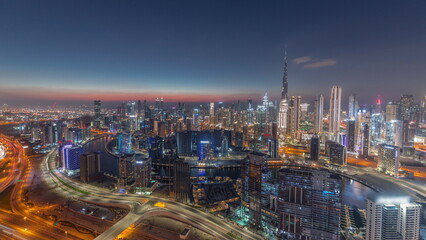 Fototapeta premium Skyline with modern architecture of Dubai business bay towers day to night timelapse. Aerial view