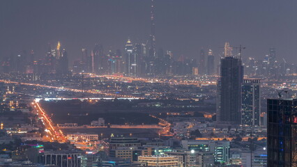 Fototapeta premium Dubai Downtown skyline row of skyscrapers with tallset tower aerial day to night timelapse. UAE