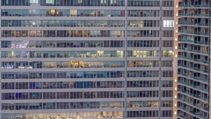 Fototapeta na wymiar Windows of office buildings day to night timelapse, the light from the windows of houses