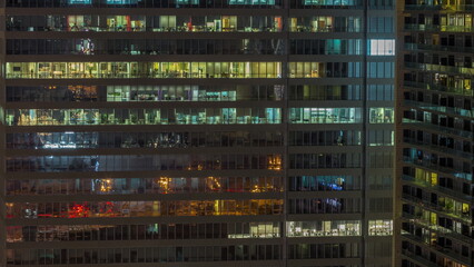 Fototapeta na wymiar Windows of office buildings at night timelapse, the light from the windows of houses