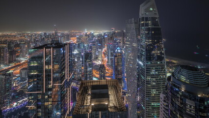 Fototapeta premium Panorama showing JBR district and Dubai Marina with JLT. Traffic between skyscrapers aerial night timelapse.