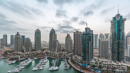 Fototapeta na wymiar Luxury yacht bay in the city aerial night to day timelapse in Dubai marina