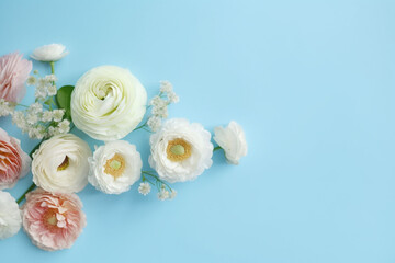 Obraz na płótnie Canvas A blue background topped with beautiful flowers such as baby's breath, rose, cherry blossom and ranunculus. for banners, cards, mockups, backgrounds and template ai-generated