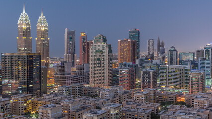 Fototapeta na wymiar Skyscrapers in Barsha Heights district and low rise buildings in Greens district aerial day to night timelapse.