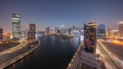 Fototapeta na wymiar Cityscape of skyscrapers in Dubai Business Bay with water canal aerial day to night timelapse