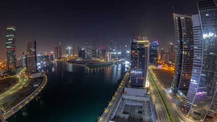 Fototapeta na wymiar Cityscape panorama of skyscrapers in Dubai Business Bay with water canal aerial all night timelapse
