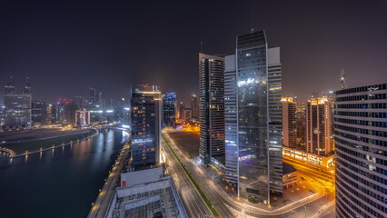 Obraz na płótnie Canvas Cityscape of skyscrapers in Dubai Business Bay with water canal aerial all night timelapse