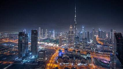 Panorama showing aerial view of tallest towers in Dubai Downtown skyline and highway night timelapse.