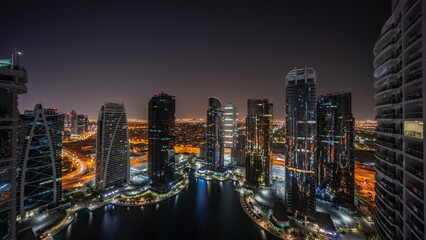 Fototapeta na wymiar Tall residential buildings at JLT aerial all night timelapse, part of the Dubai multi commodities centre mixed-use district.