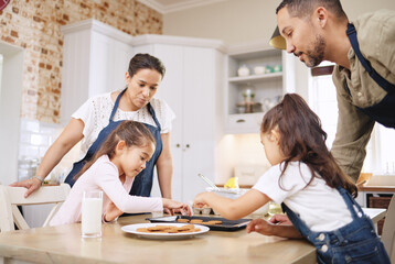 Fototapeta premium Baking is love made visible. Shot of a couple and their children baking together at home.
