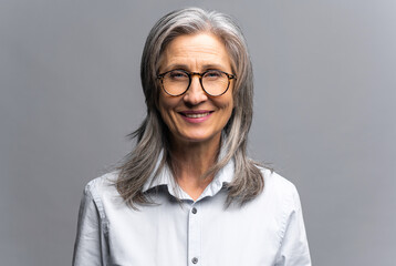 Smiling gray-haired female business woman wearing formal clothes standing with pleasure smile...