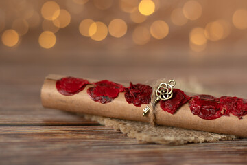 Ancient scroll with seven seals and golden key isolated on wooden table with blurred bokeh...