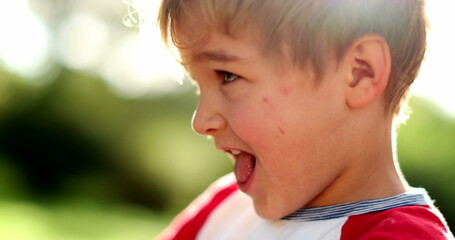 Happy toddler boy child in outdoors. Expressive joyful kid outside