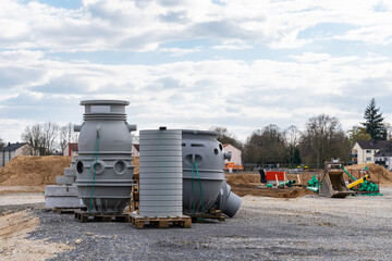 Large gray cylindrical parts made of palstic at a construction site.