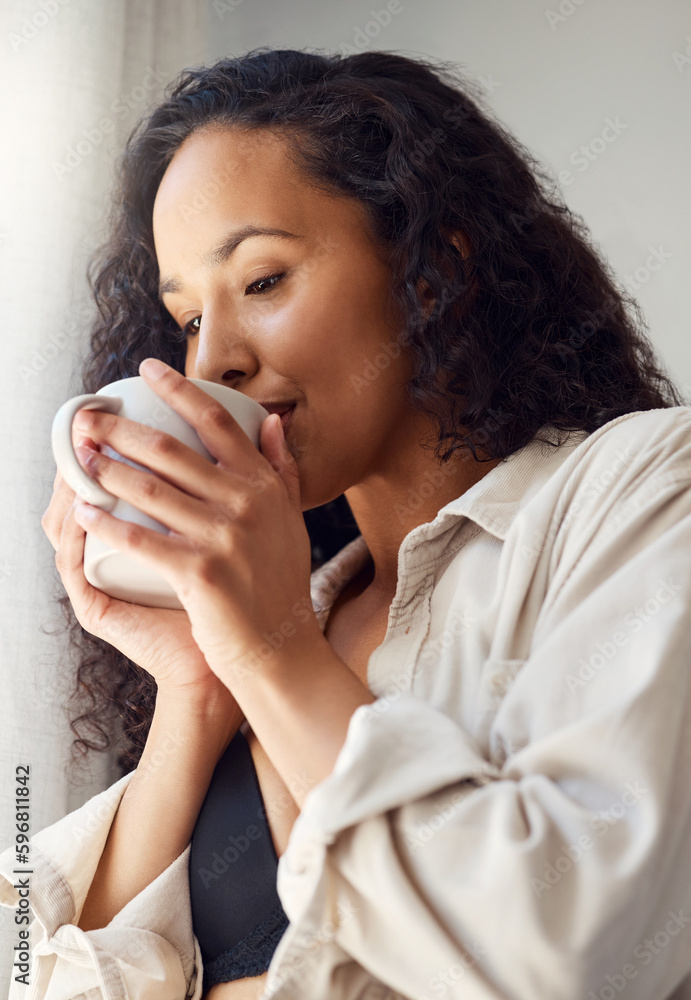 Wall mural savouring every sip. shot of a young woman enjoying a coffee at home.