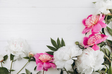 Pink and white peonies on a white wooden background, copy space, flat lay, greeting card.