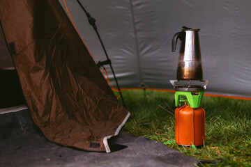 A compact gas burner, a fuel cylinder covered with a brown leather cover, geyser coffee maker....