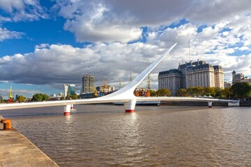 The Women's Bridge or Puente Del Mujer, a counterweight pylon pedestrian cable-stayed bridge in Puerto Madero, City of Buenos Aires, Argentina with Urban Highrise buildings in the Background