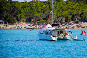 Catamaran anchored in the Mediterranean Sea in front of the beach of Cala Agulla on the eastern...