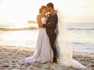 I pledge to honour you, love you and cherish you. Shot of a young couple on the beach on their...