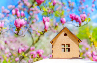Wooden Toy House against Vivid Pink Magnolia Background