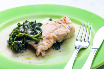 poultry breast with spinach leaves and sauce