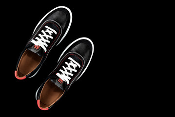 Men's sports shoes on a black background. White shoelaces. Empty space for an inscription