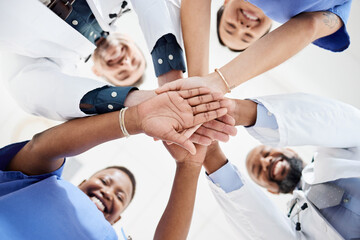 Weve made good progress this month. Shot of a group of medical practitioners joining their hands together in a huddle.