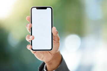 Its an app that everyone should be using. Cropped shot of an unrecognizable businessman holding up his cellphone to display the screen while standing in the office.