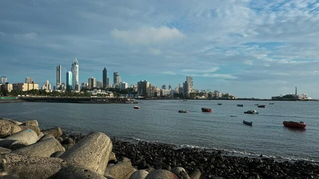 Time-lapse of Mumbai city skyline view from Haji Ali Dargah Bay on a clear sunny day. South Bombay view as seen from a tetrapod beach in Mumbai. Sea view and skyscraper buildings near Haji Ali. 4K